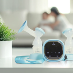 Zomee Breast Pumps on a kitchen counter with mom and baby in the background