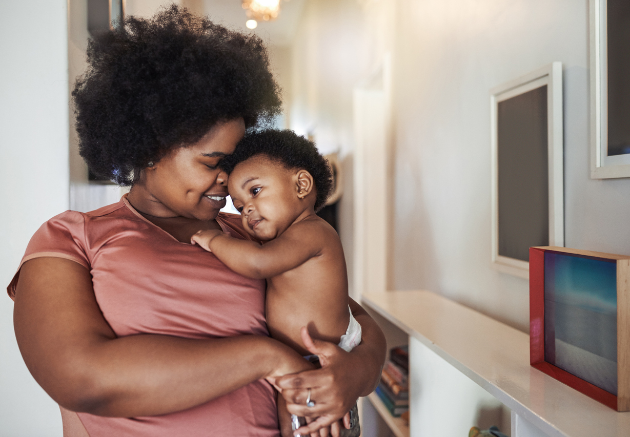 A mother lovingly holding her baby close, representing the bonding moments made easier with Elvie breast pumps. This image highlights the convenience and freedom Elvie breast pumps offer, allowing moms to balance breastfeeding and bonding with their little ones.