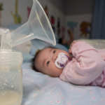 A baby lying on a bed with a pacifier, next to a bottle and breast pump, illustrating how new mothers can access a breast pump through Medicaid for support in their breastfeeding journey.