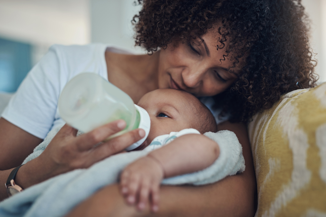 A mother lovingly feeding her baby with a bottle, showcasing the benefits of breast pumping. This image reflects breast pumping tips that can help moms provide nourishment and bond with their little ones.